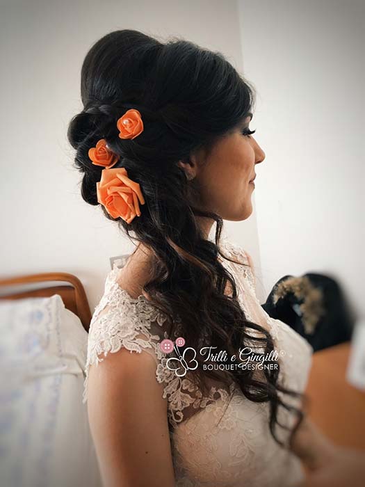 acconciatura sposa con rose arancioni tra i capelli